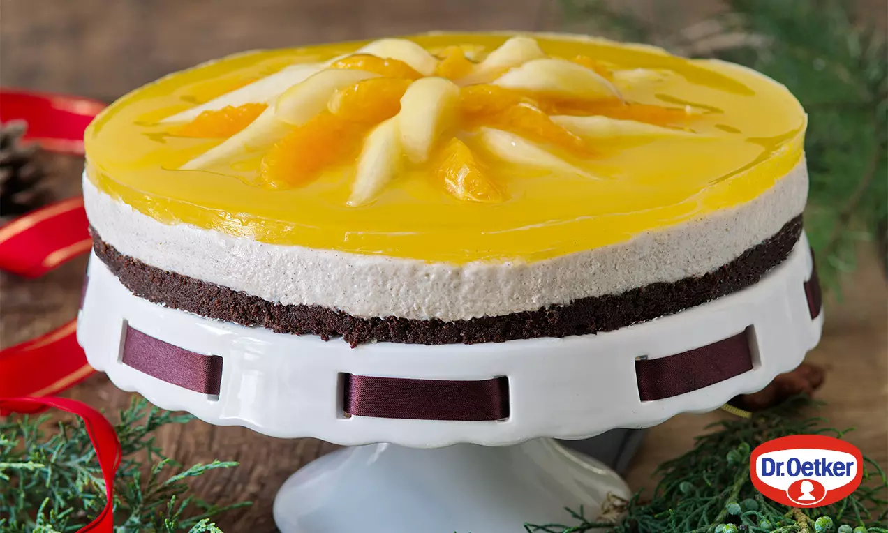 Adventní dort na bílé podložce, vrstvy tmavého korpusu, světlého krému a hladkého žlutého želé s plátky ovoce vytvarované do hvězdy